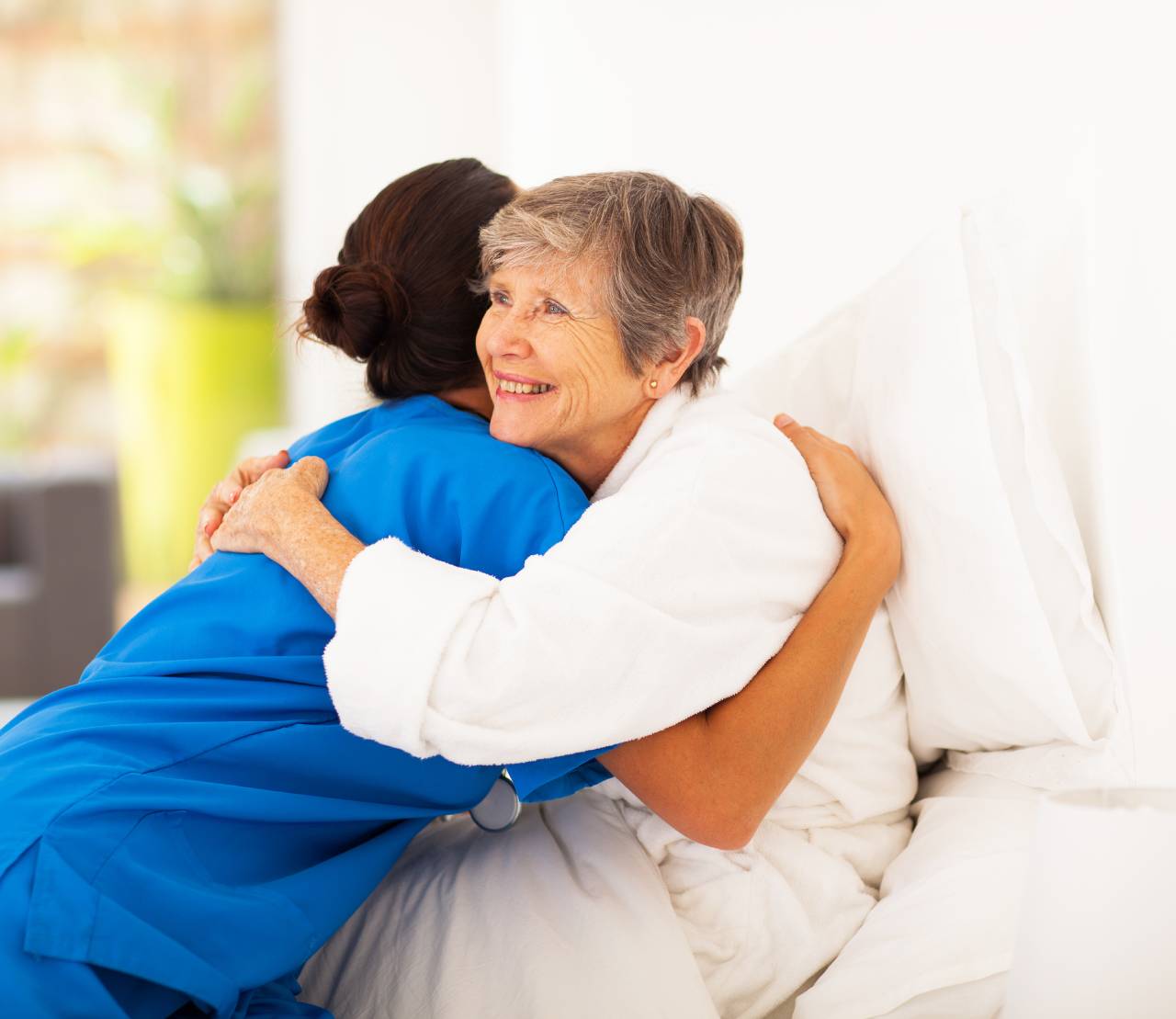 Cuidadora abraza mujer mayor